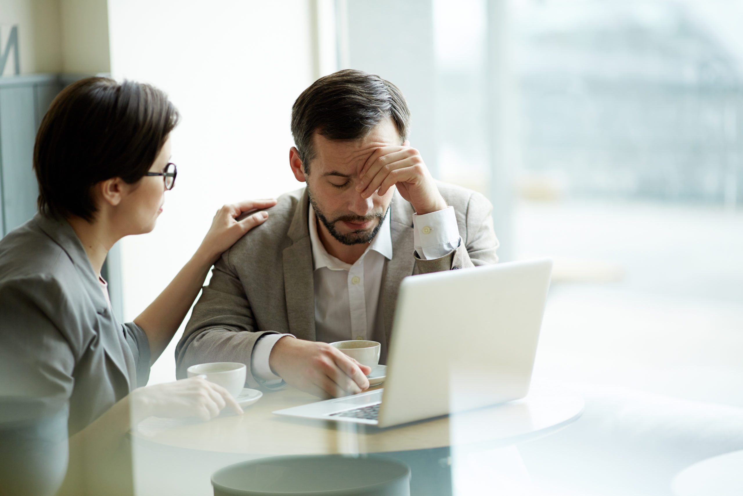 Empresaria consolando con empatía a un compañero de trabajo frustrado o cansado